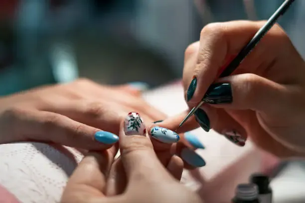 manicure beauty and relax young woman getting her nails done in salon by manicure worker